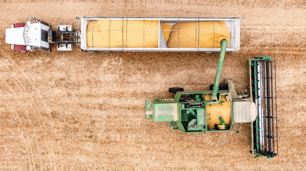 Aerial photo of a combine unloading soybeans into a semi. 